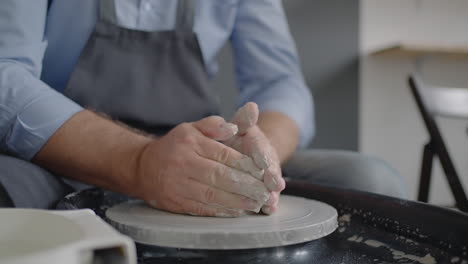 Close-up-of-the-hand-of-a-male-potter-making-a-ceramic-plate-in-slow-motion